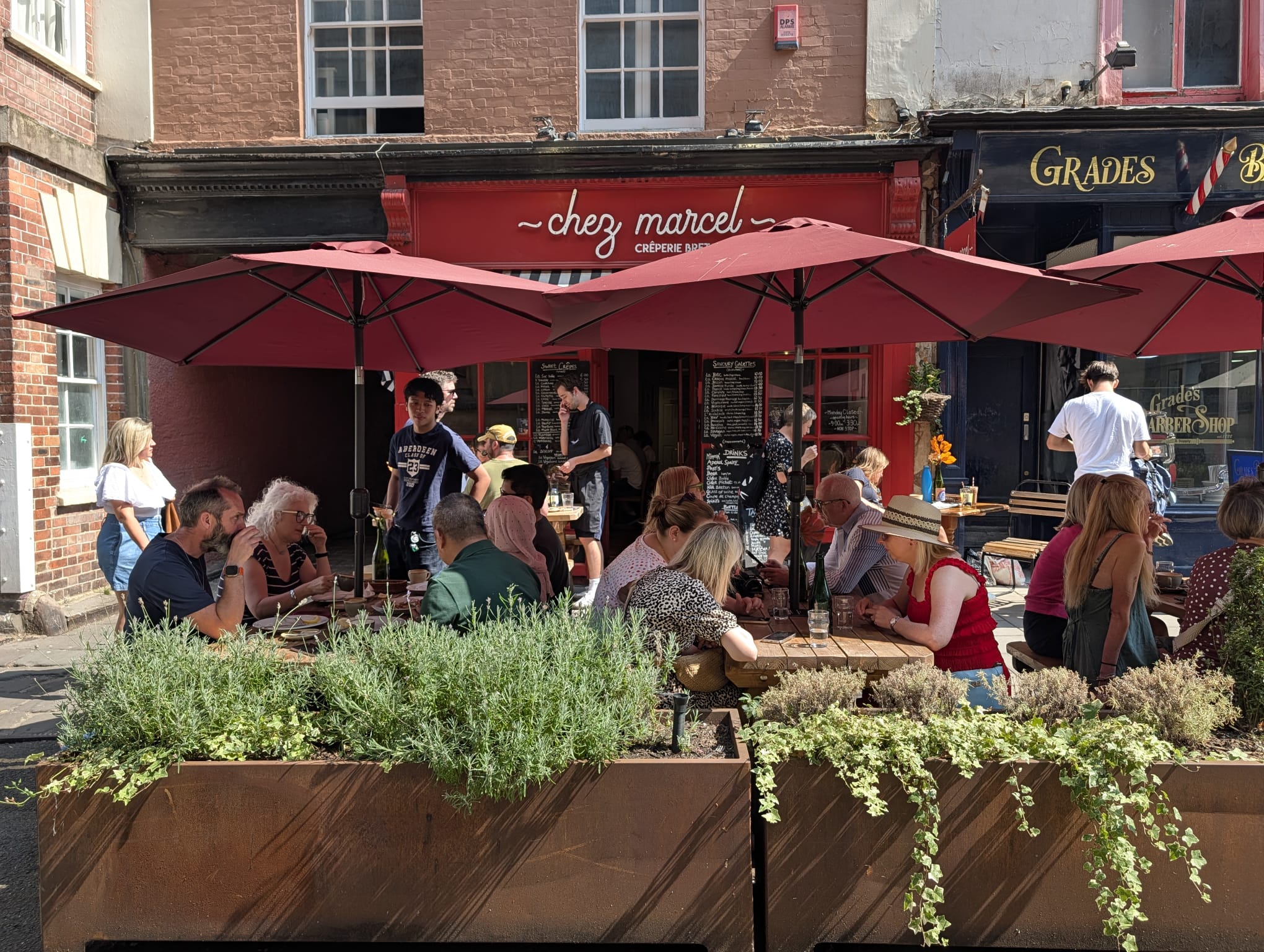 The sunny terrace of Chez Marcel creperie bretonne in Bristol old city centre, full of guests